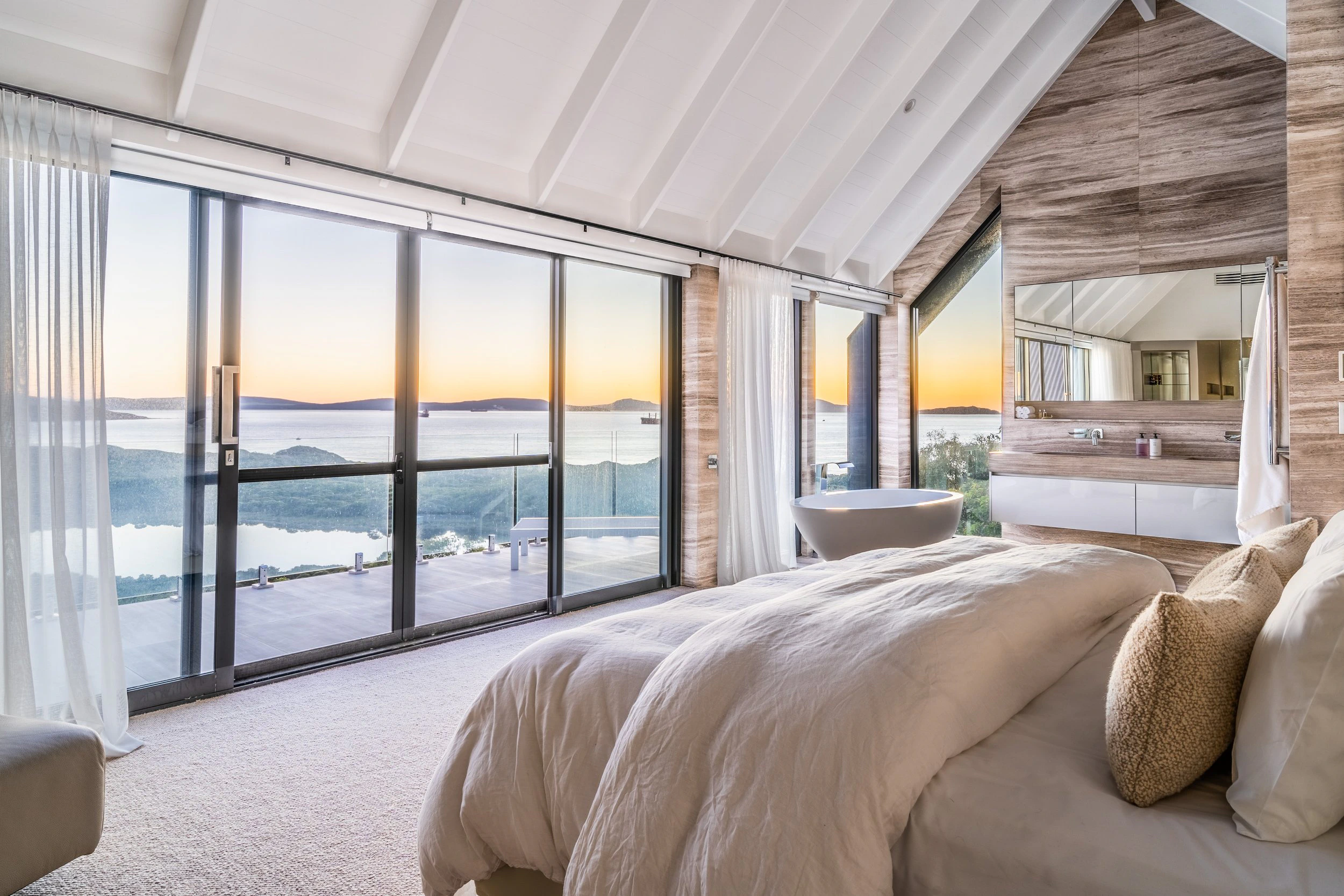 Bedroom interior overlooking ocean sunset view