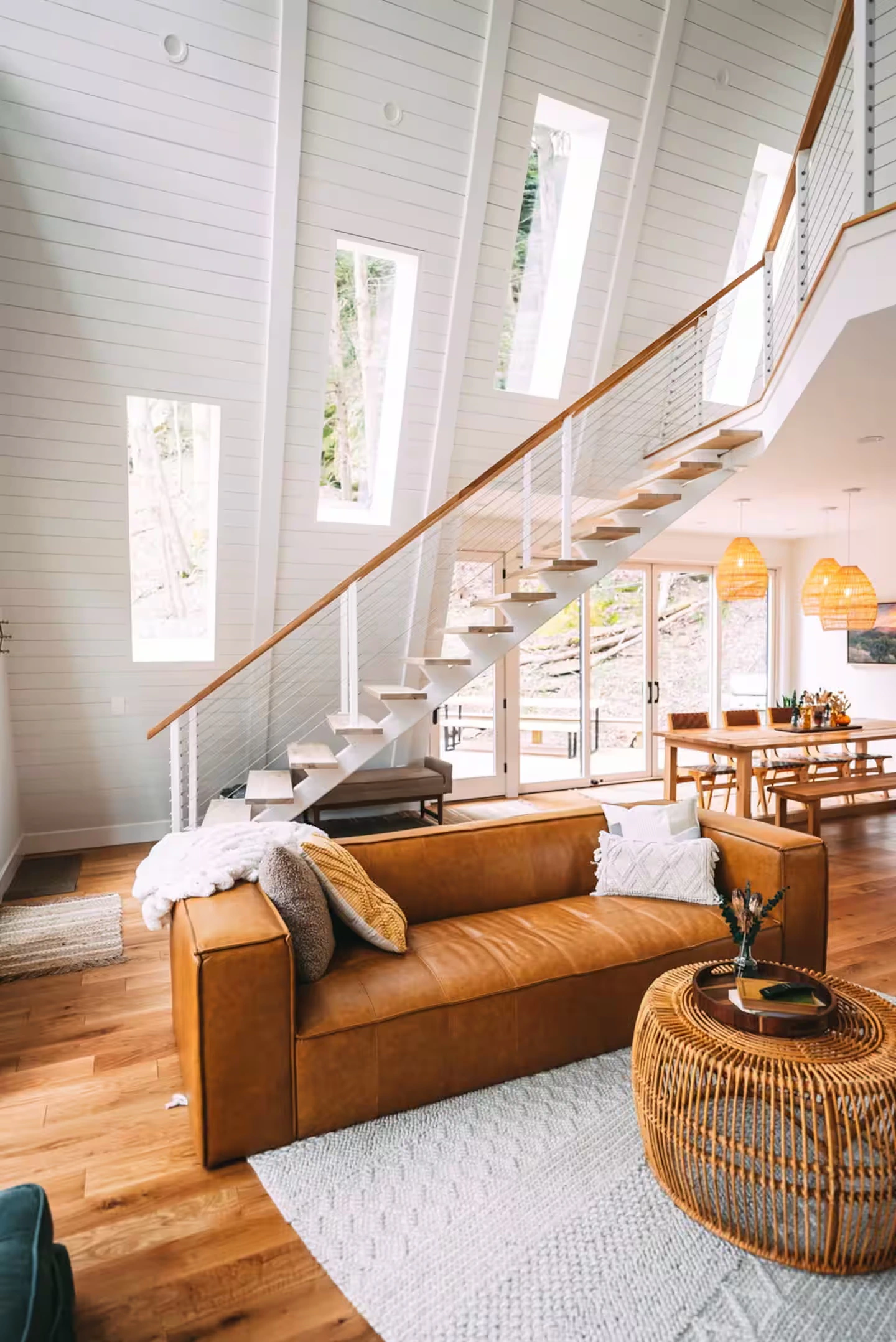 A-frame living room with staircase and dining area