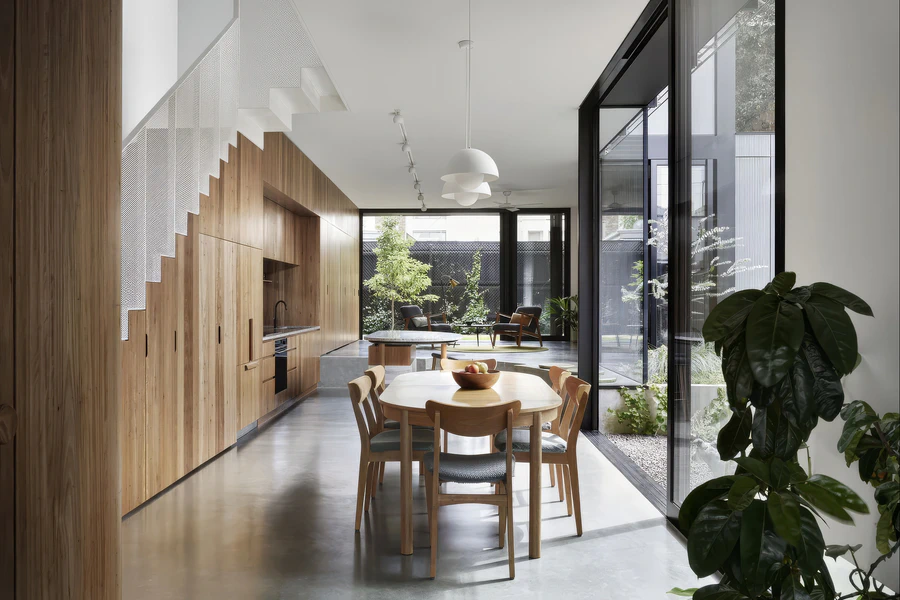 Open-plan dining area beside timber kitchen and internal courtyard