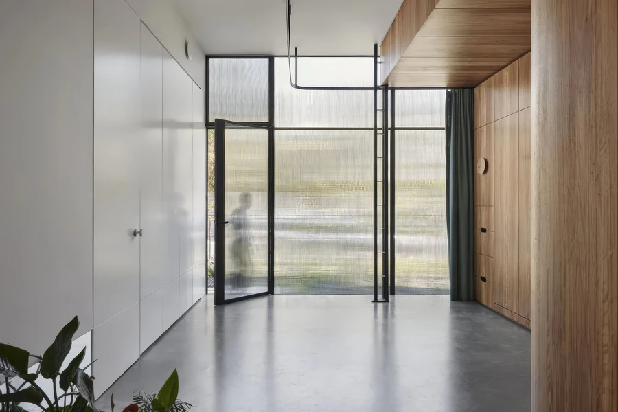 Minimal interior room with timber wall panels and translucent glass doors