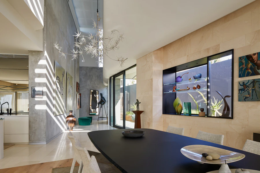 Dining area beside stone feature wall and illuminated display shelf