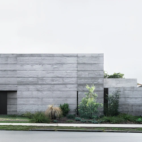 Contemporary concrete house exterior with native garden