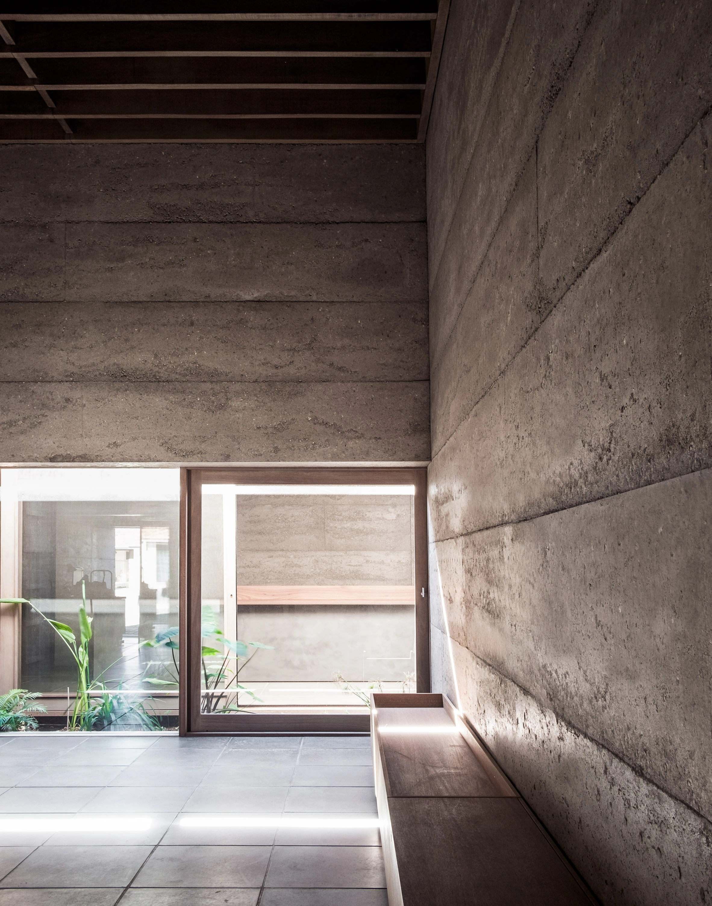 Rammed earth interior wall and window seat in modern house