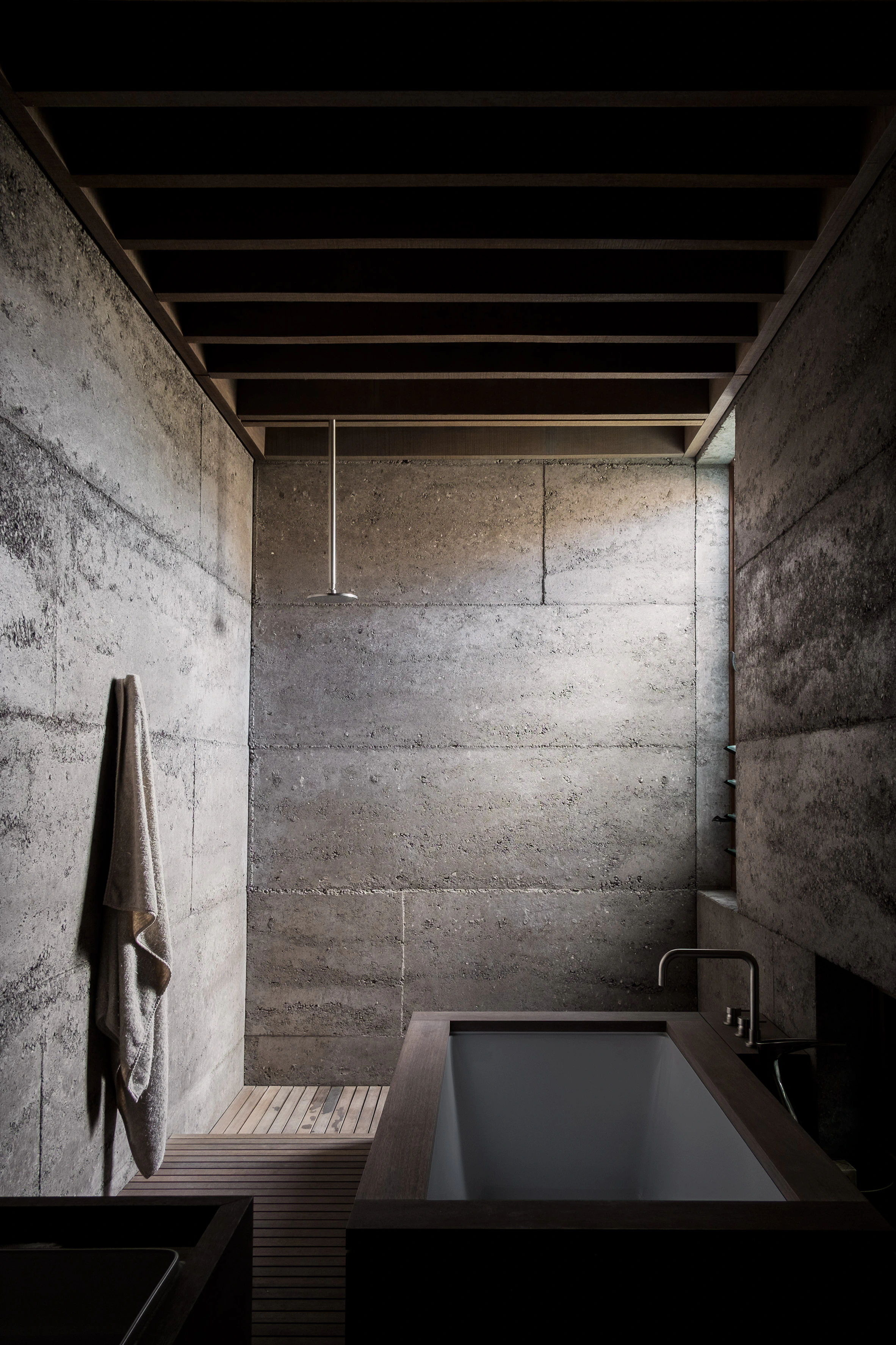Concrete bathroom with bathtub and overhead shower