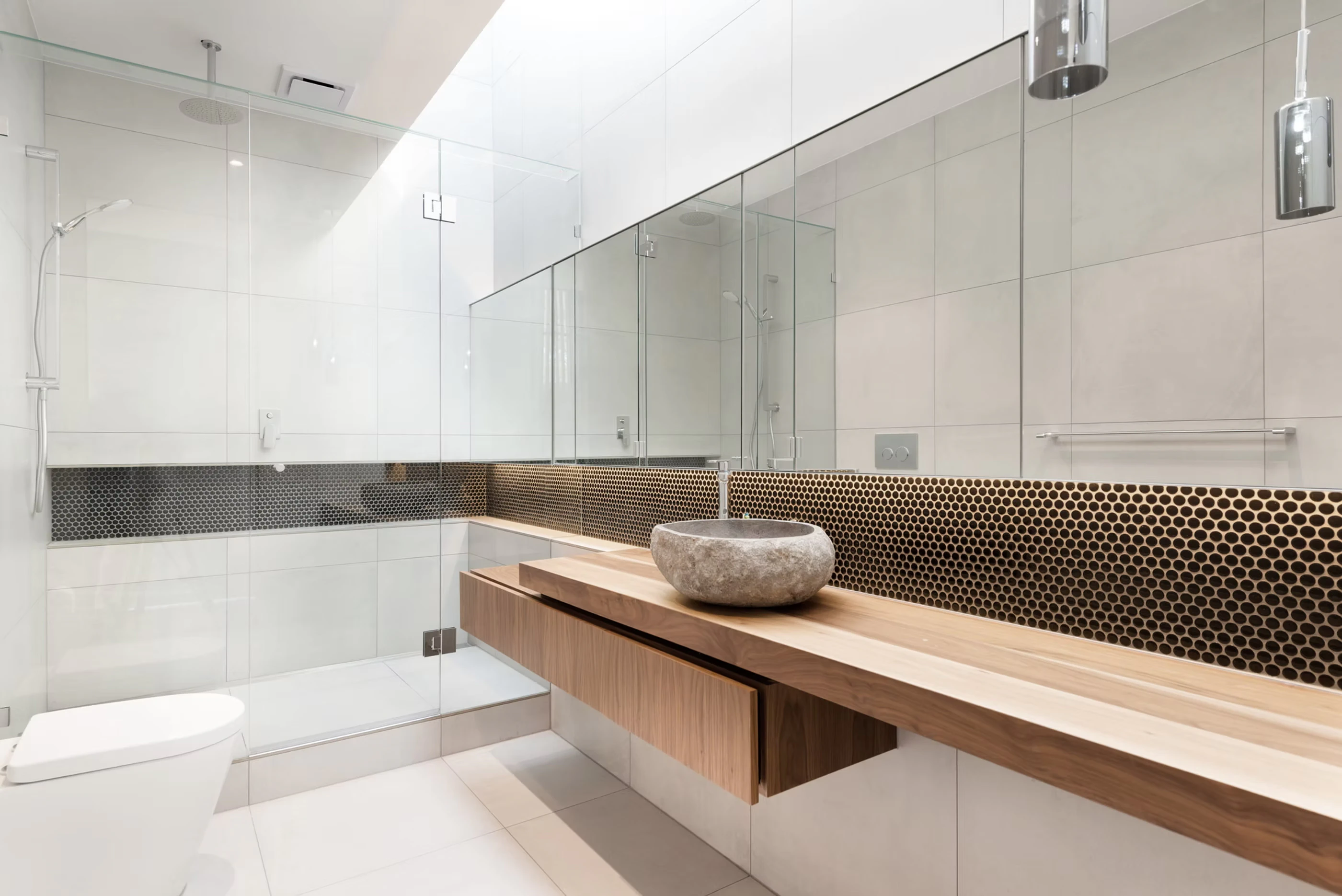 Modern minimalist bathroom with glass-enclosed shower, wall-mounted mirror, concrete sink basin, and wooden vanity