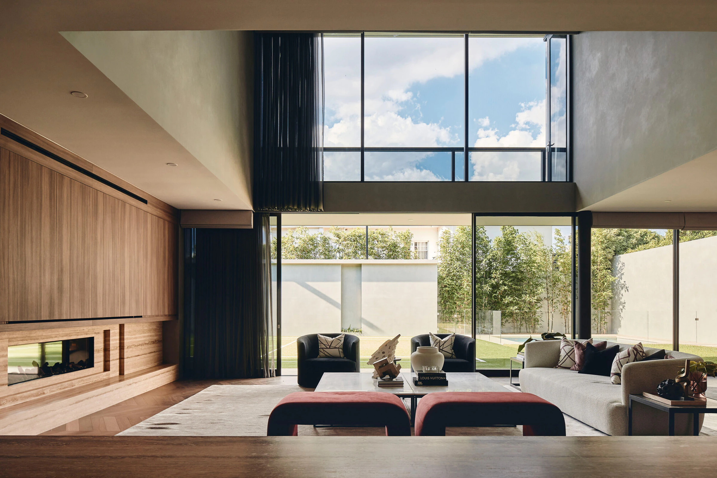 Double-height living room, timber wall, concrete planes and garden glazing