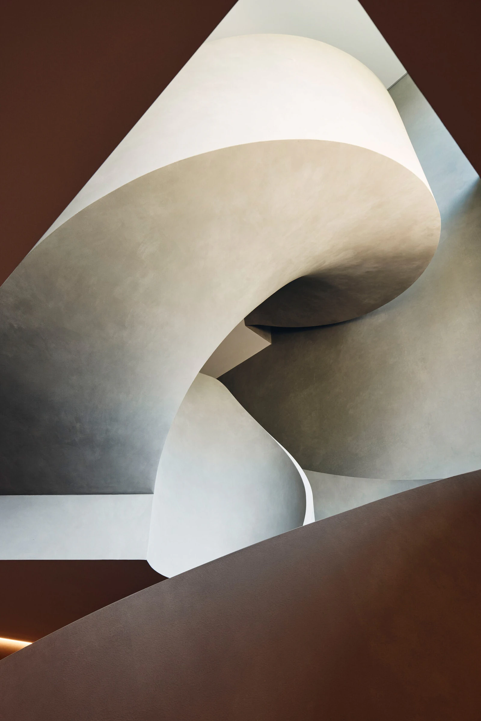 Sculptural concrete staircase beneath rectangular skylight in Toorak home
