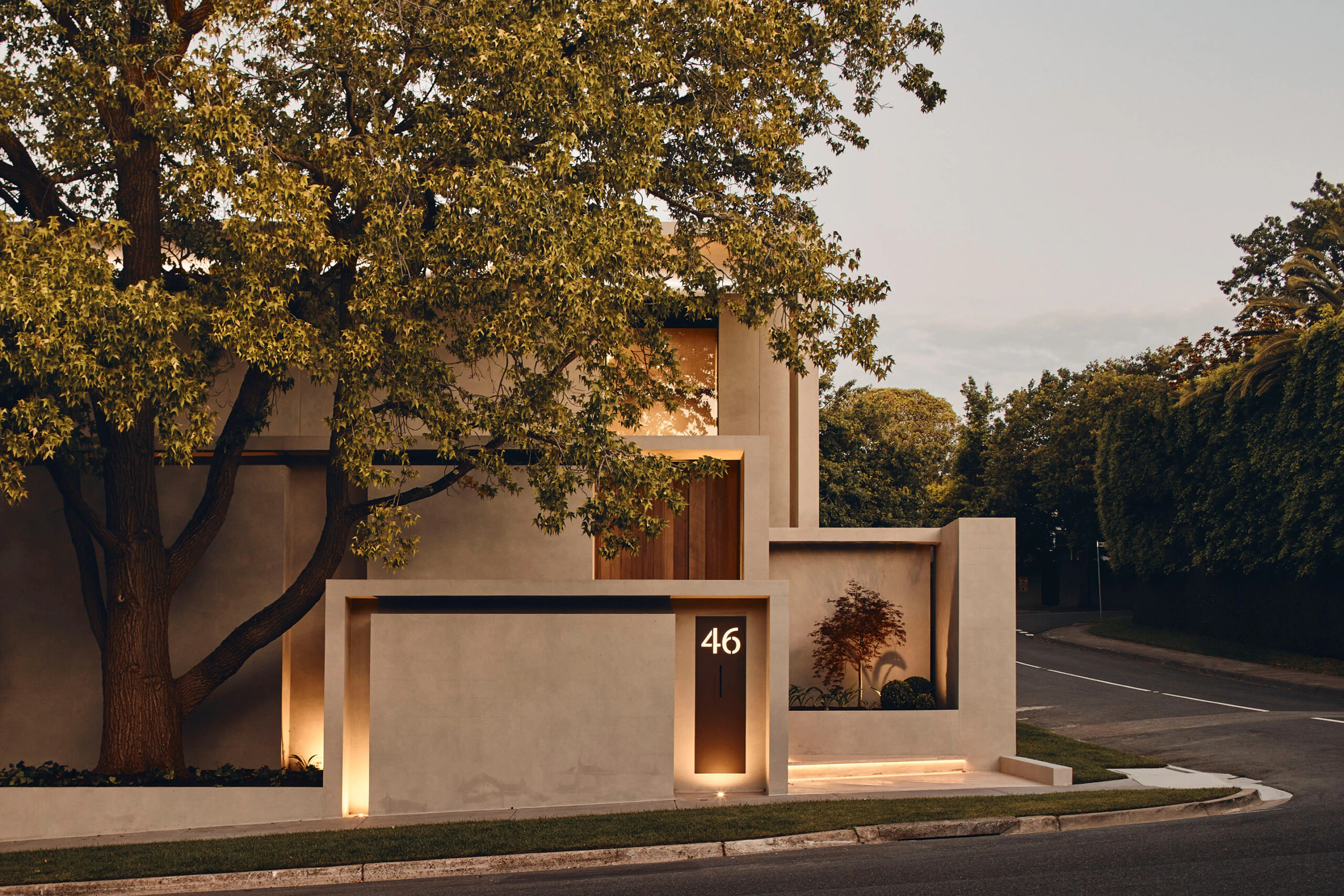 Concrete boundary wall and illuminated Toorak house entrance