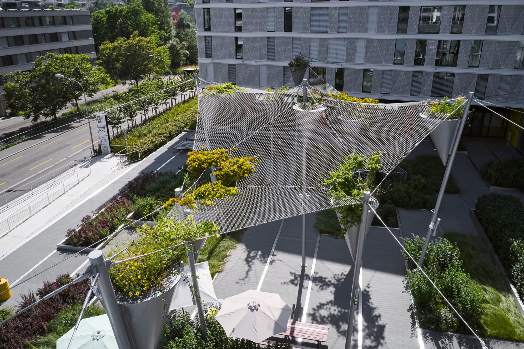 Planted cable canopy over Emil North communal plaza in Zurich