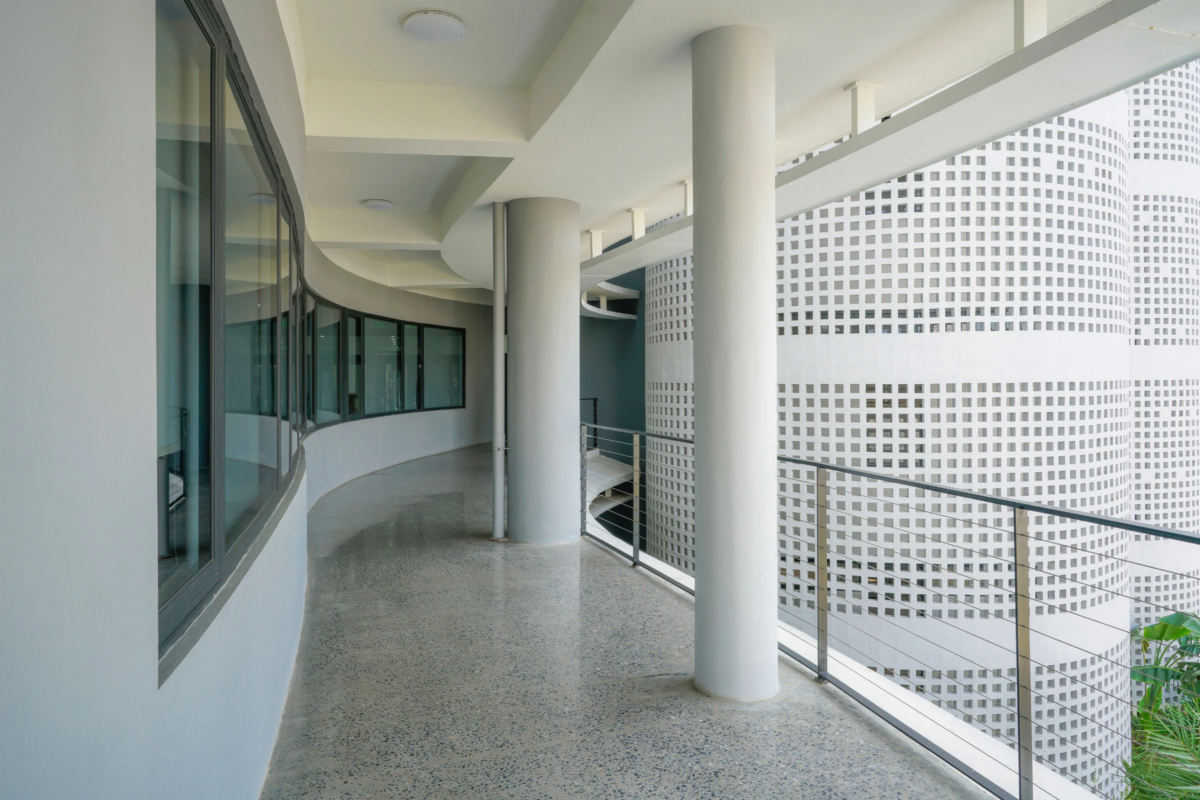 Curved office corridor and cylindrical columns at Infinity Village