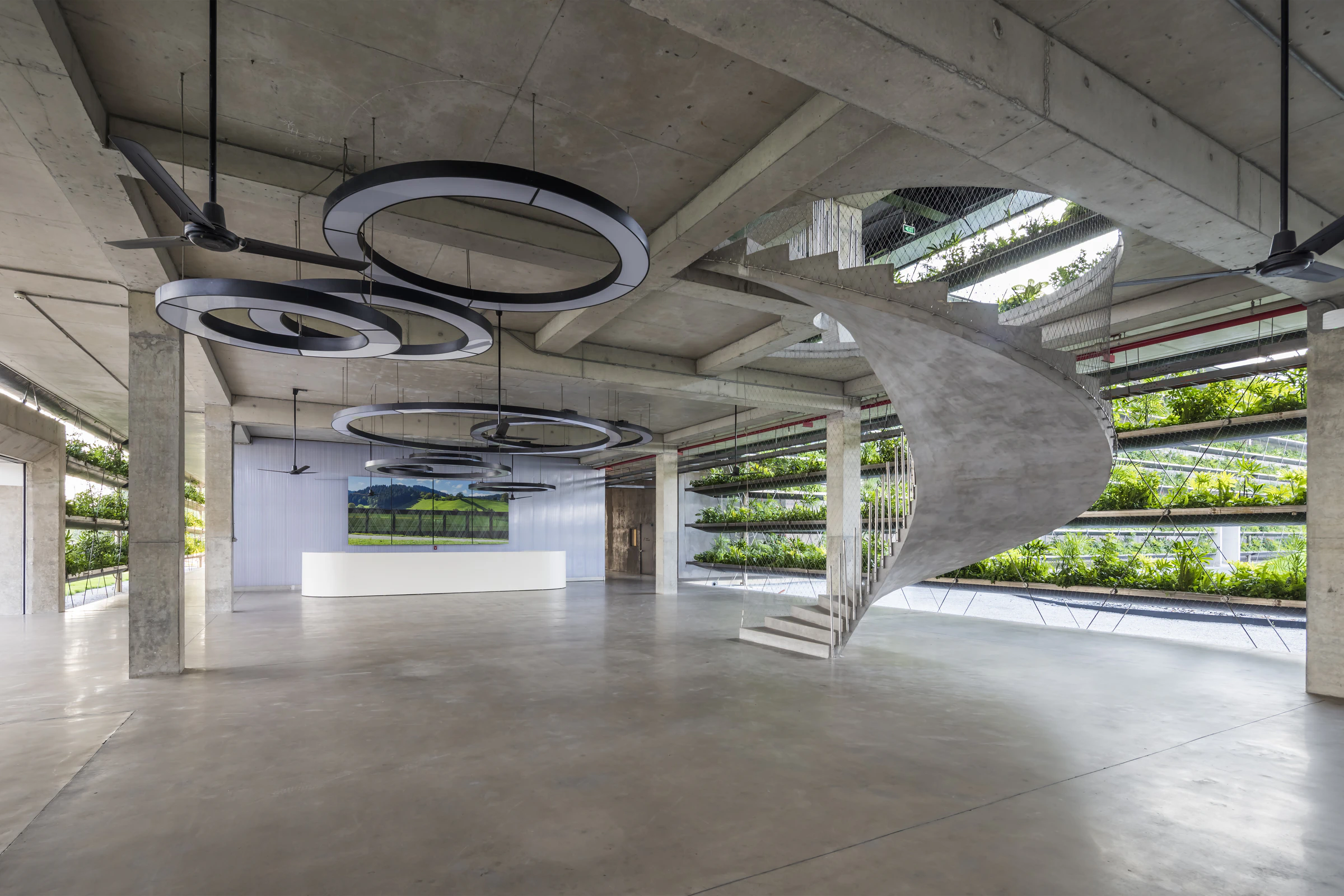 Jakob Factory concrete interior, spiral staircase and planted façade