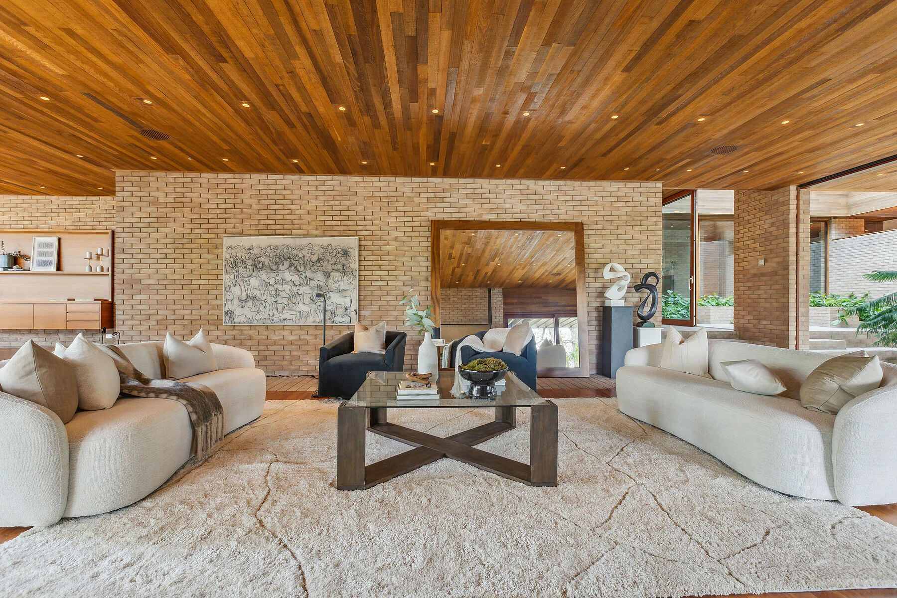 Spacious living room with wooden ceiling and brick walls