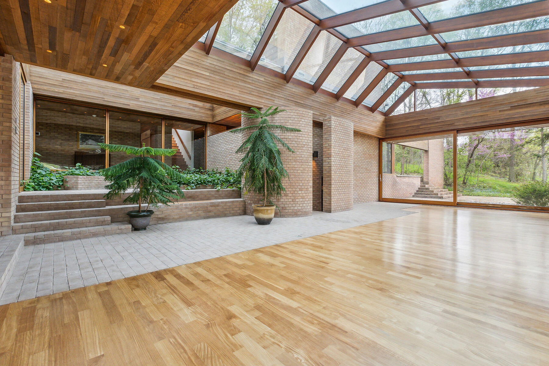 Open-plan living area featuring skylights, brick walls and large windows
