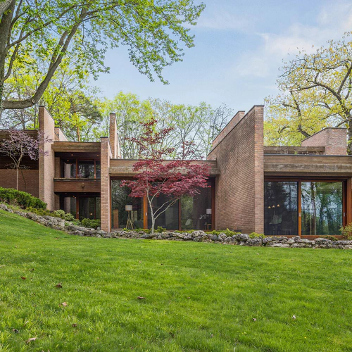 Brick house surrounded by trees and lawn