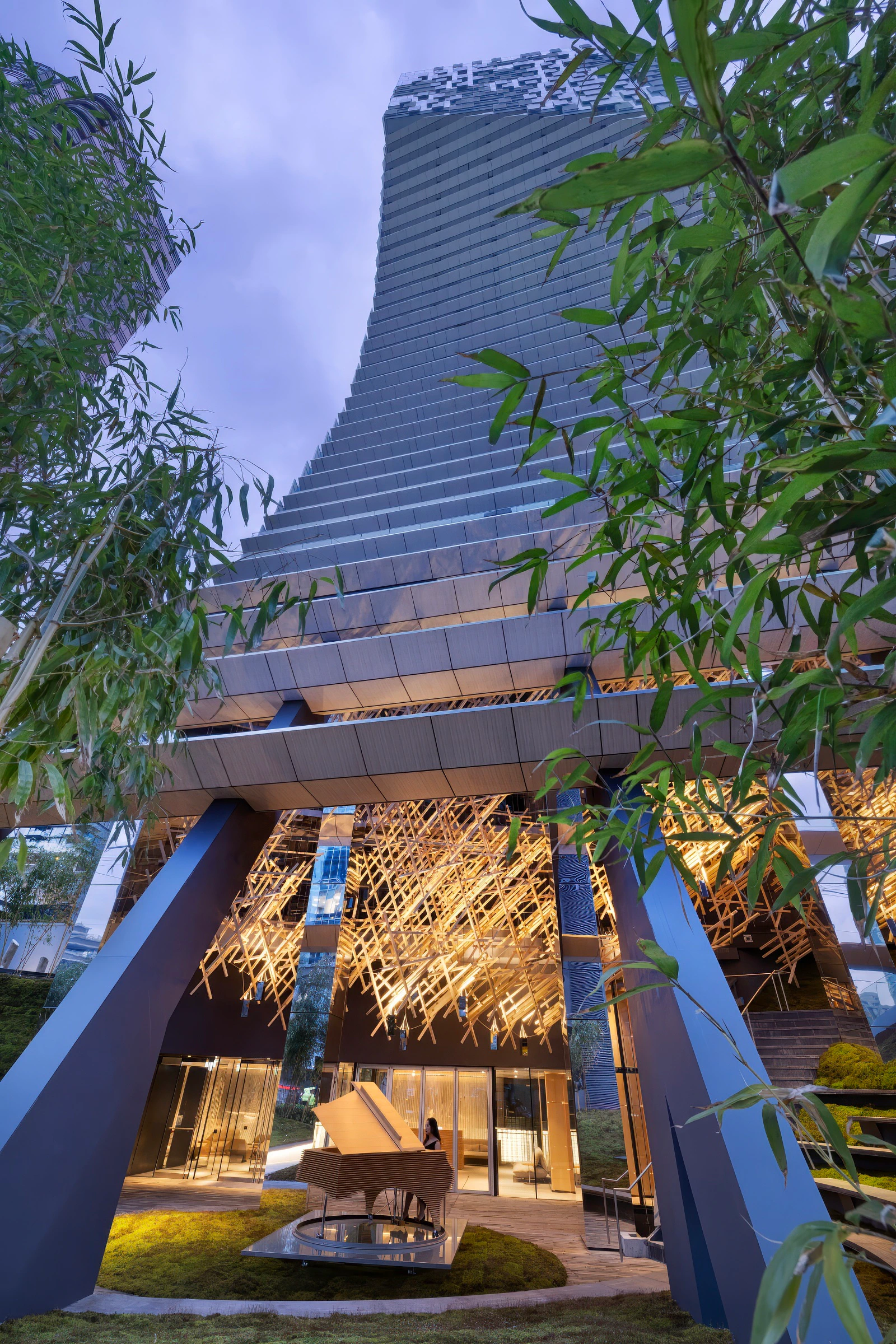 Alberni by Kengo Kuma entrance with illuminated architectural details and piano