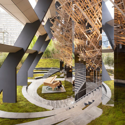 An open-air amphitheatre featuring a suspended cloud of interlocking members