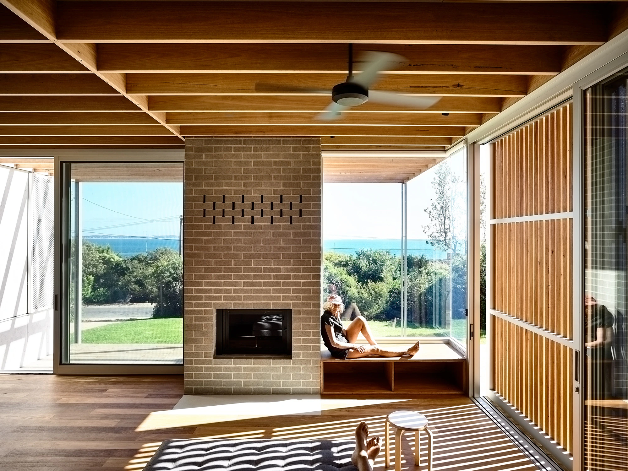Exposed brick hearth and timber screens in Seaberg beach house