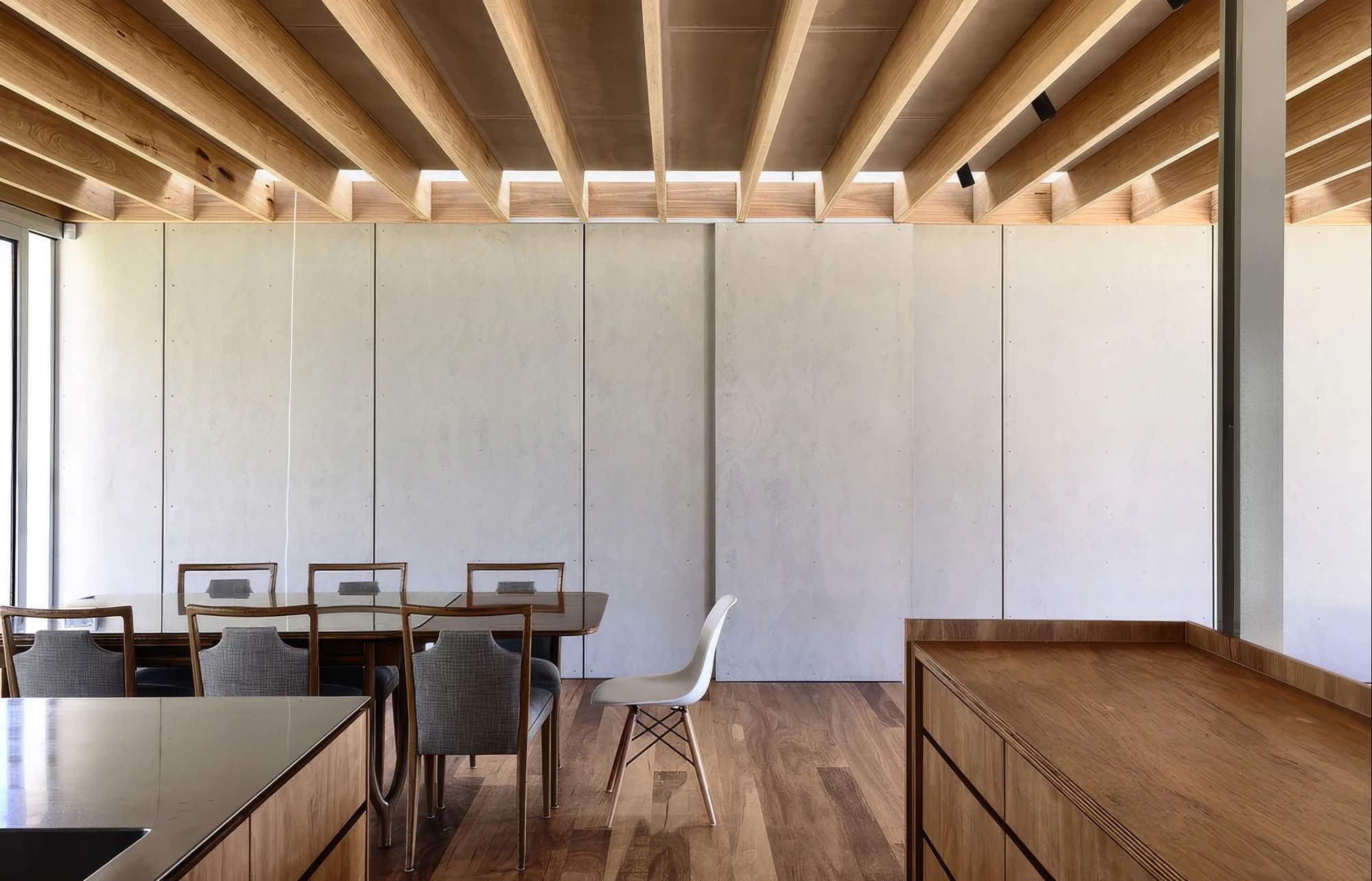 Seaberg dining area beneath exposed timber beams and plywood joinery