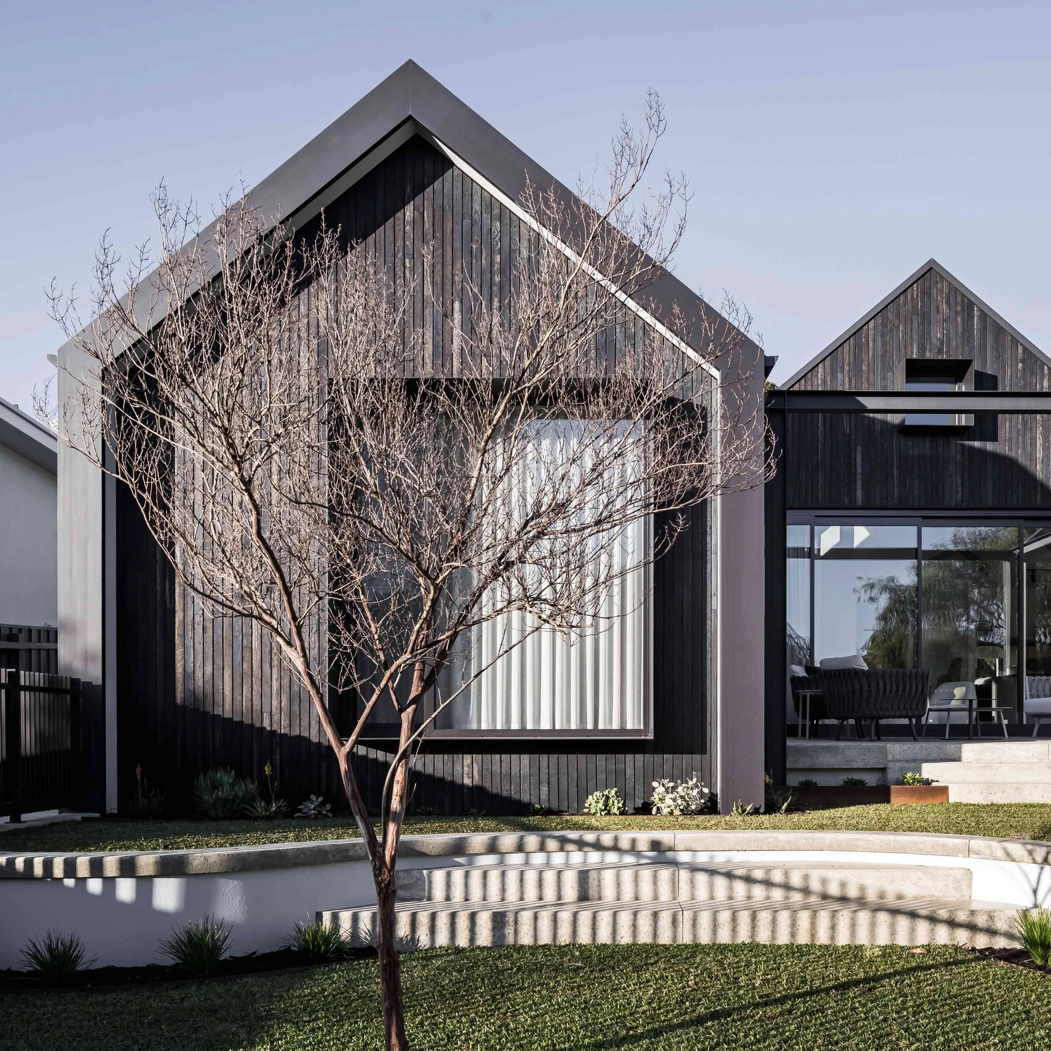 Shou Sugi Ban gabled home façade and curved landscaping