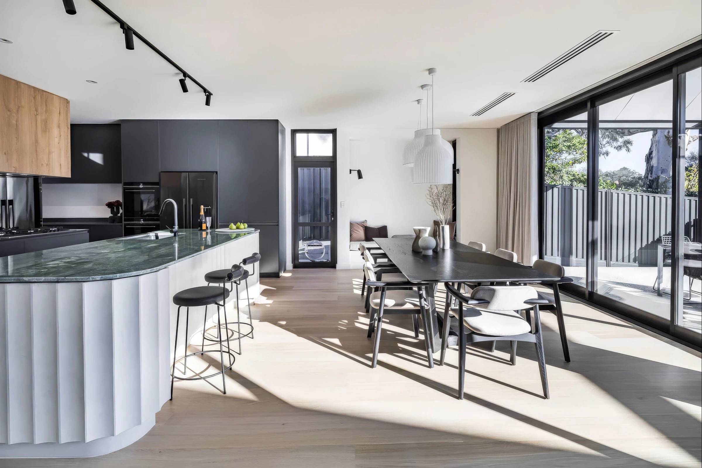 Open-plan kitchen dining area, green quartzite island and timber floors