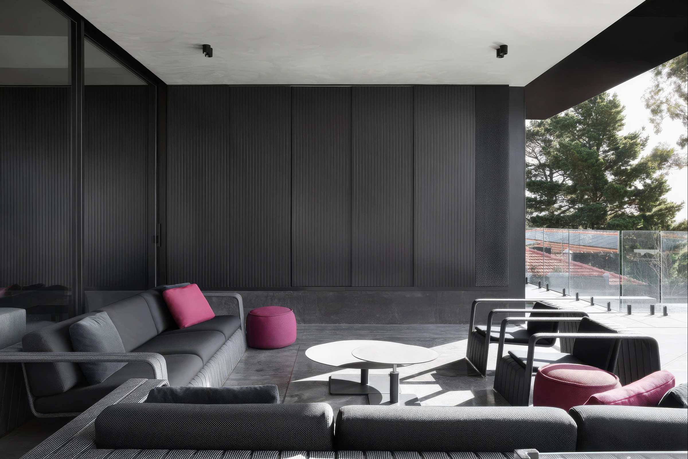 Covered patio seating area beside glass balcony and black wall panels