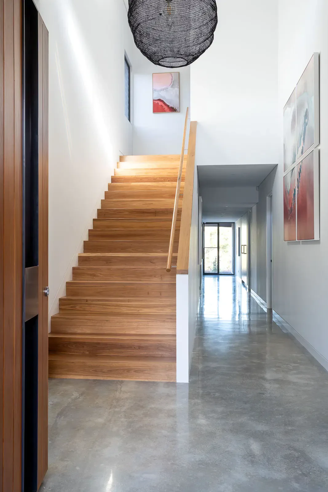 Wooden staircase with a sleek handrail in a modern hallway