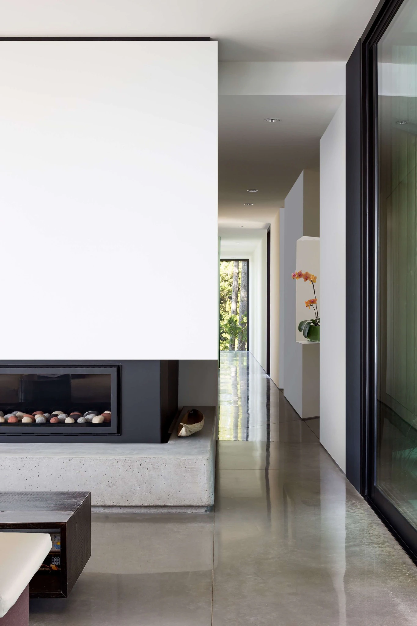 Modern interior hallway with a built-in fireplace and large windows