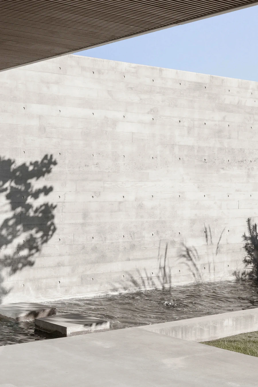 Concrete wall beside shallow water feature