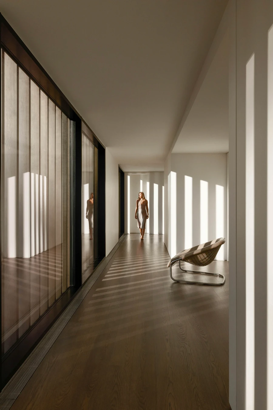 Sunlit hallway with wooden floor and modern chair