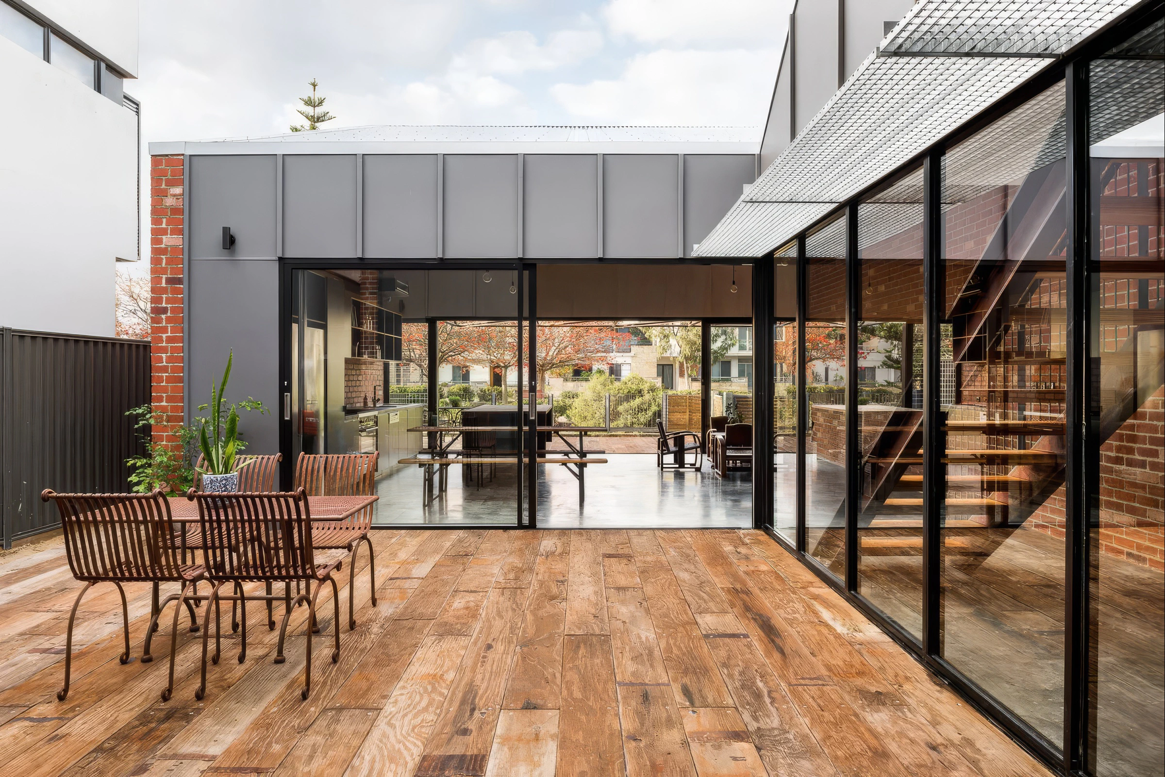 Industrial courtyard glazing, timber deck and exposed steel stair