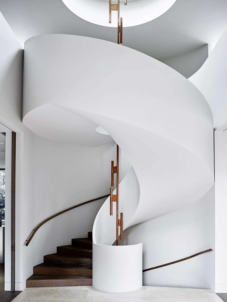 White spiral staircase with wooden steps and handrails in minimalist interior design