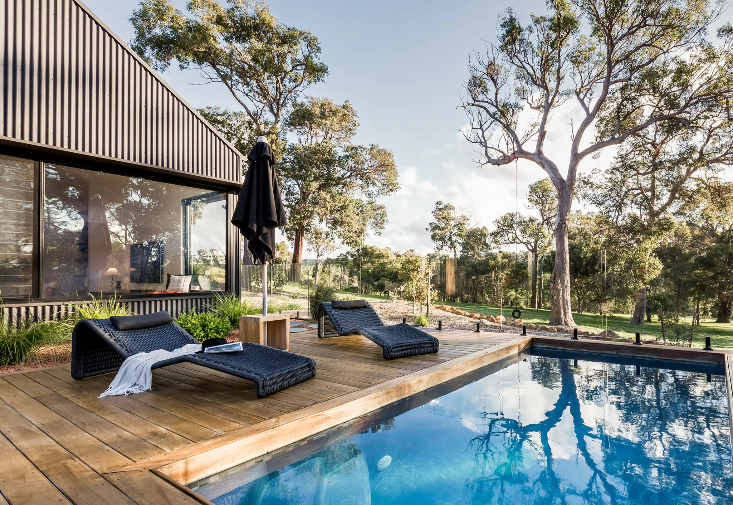 Outdoor swimming pool area with lounge chairs and surrounding trees