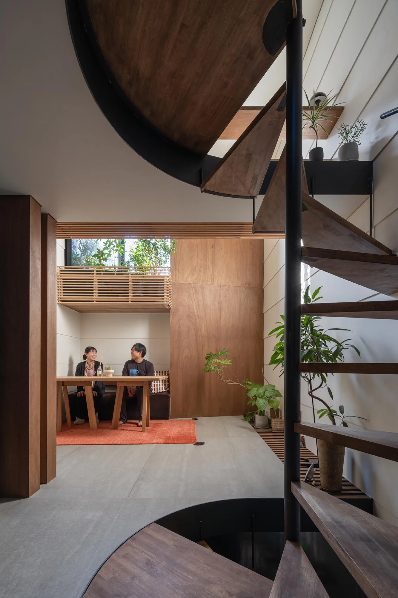 Vertical machiya interior, circular timber stair and central void