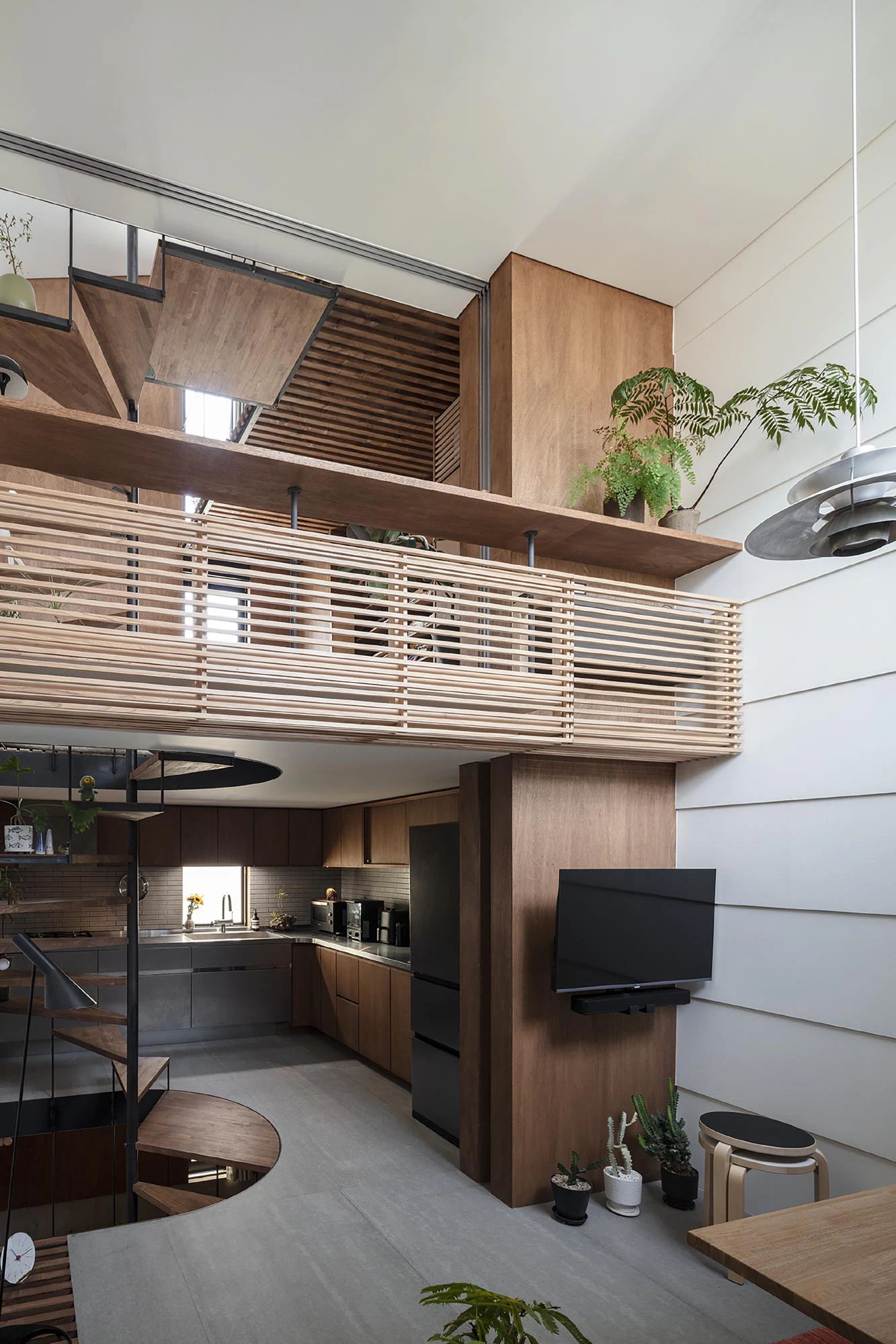 Vertical machiya interior, timber mezzanine and compact kitchen
