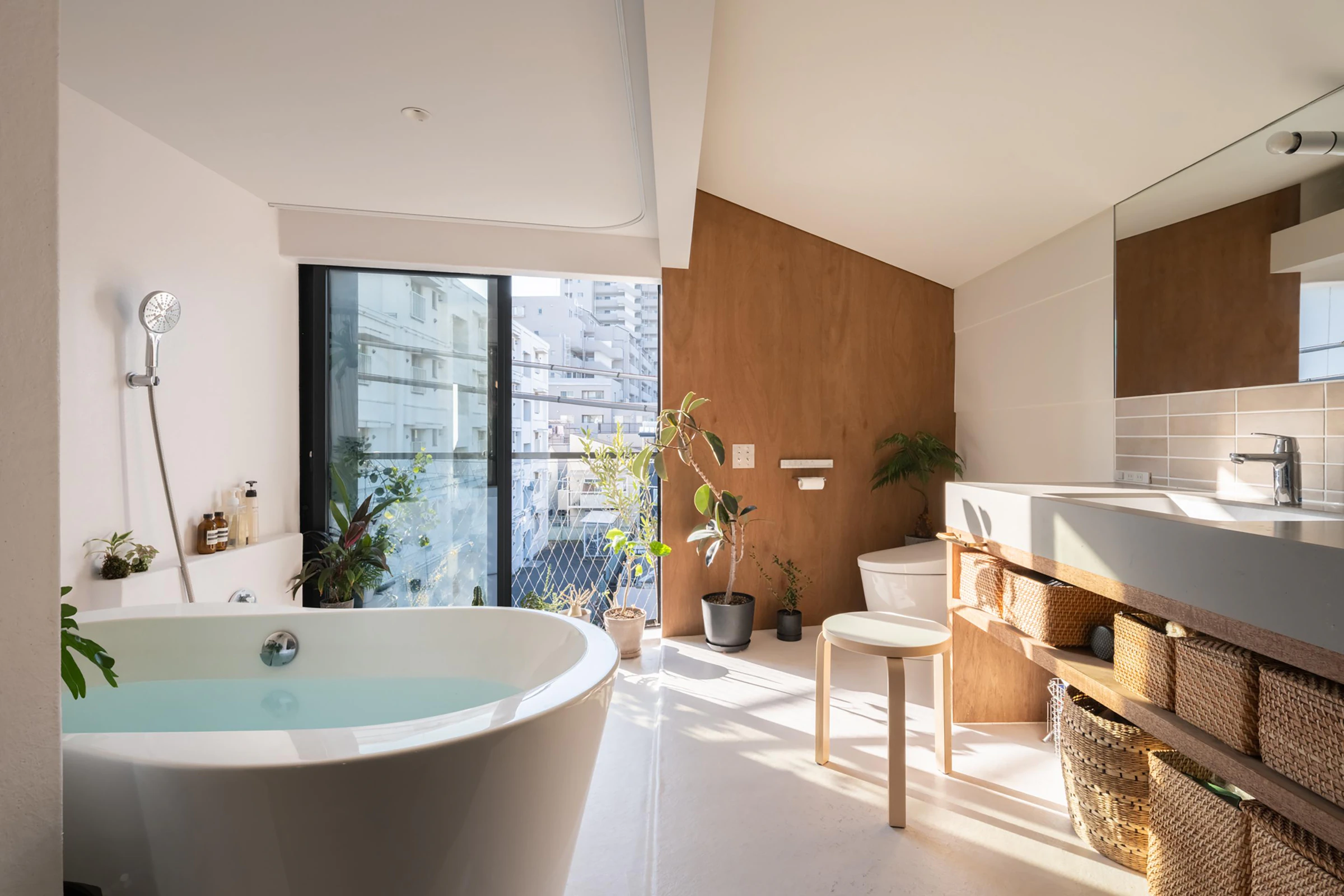 Freestanding bath and timber vanity in compact Tokyo bathroom