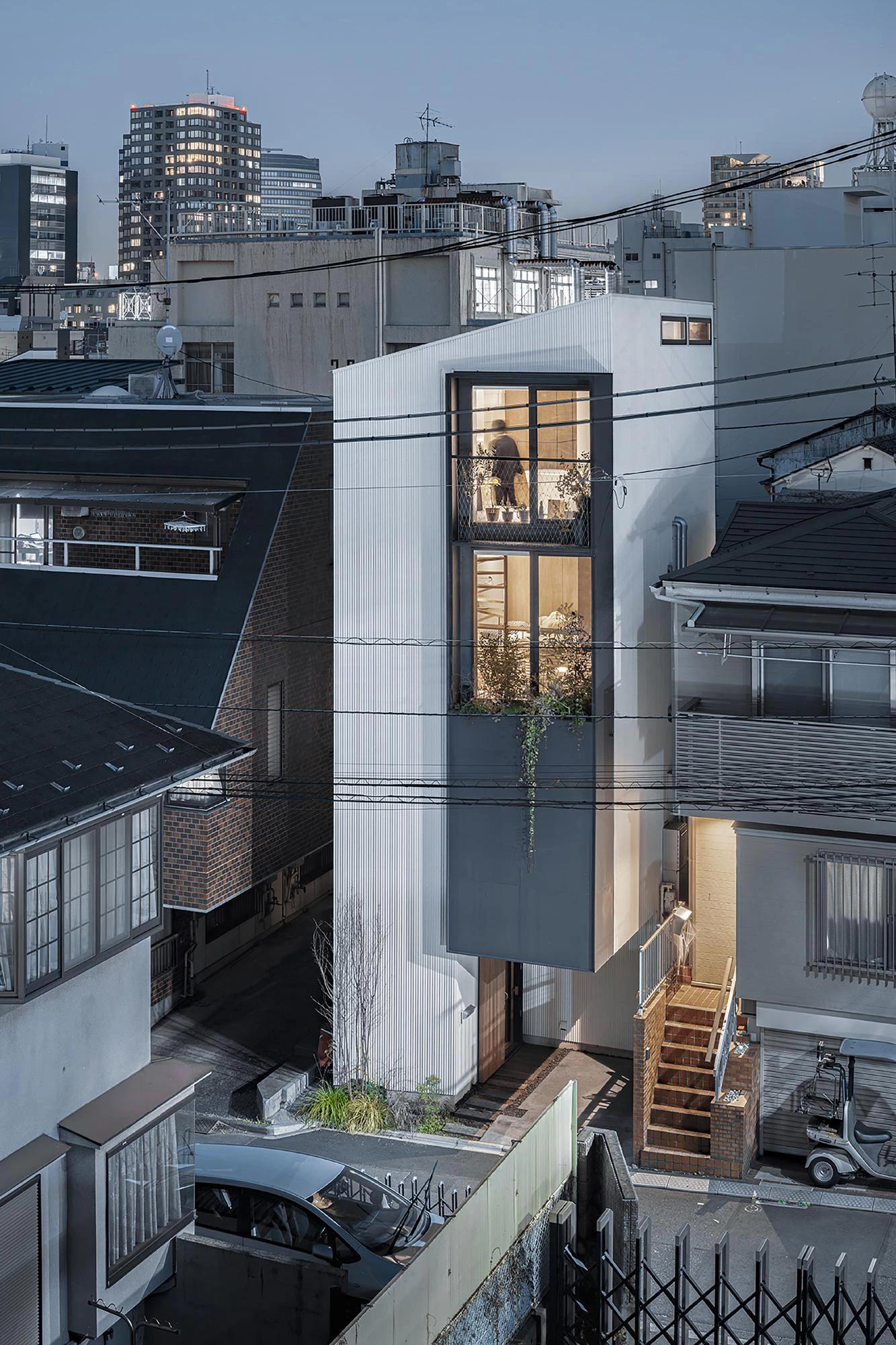 Slim white Kagurazaka townhouse between dense urban rooftops