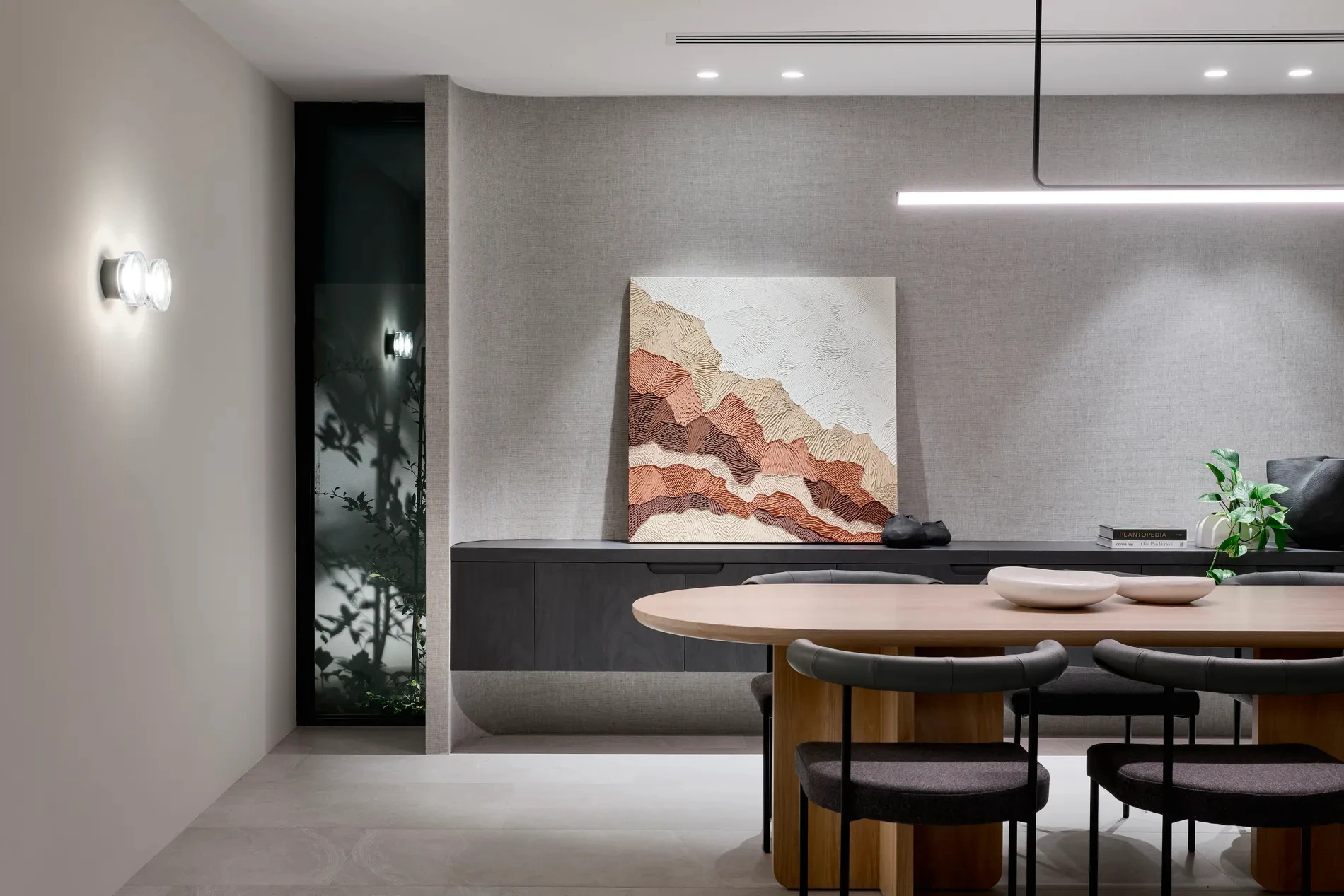 Interior dining area with a wooden table, black upholstered chairs, and modern ceiling lighting