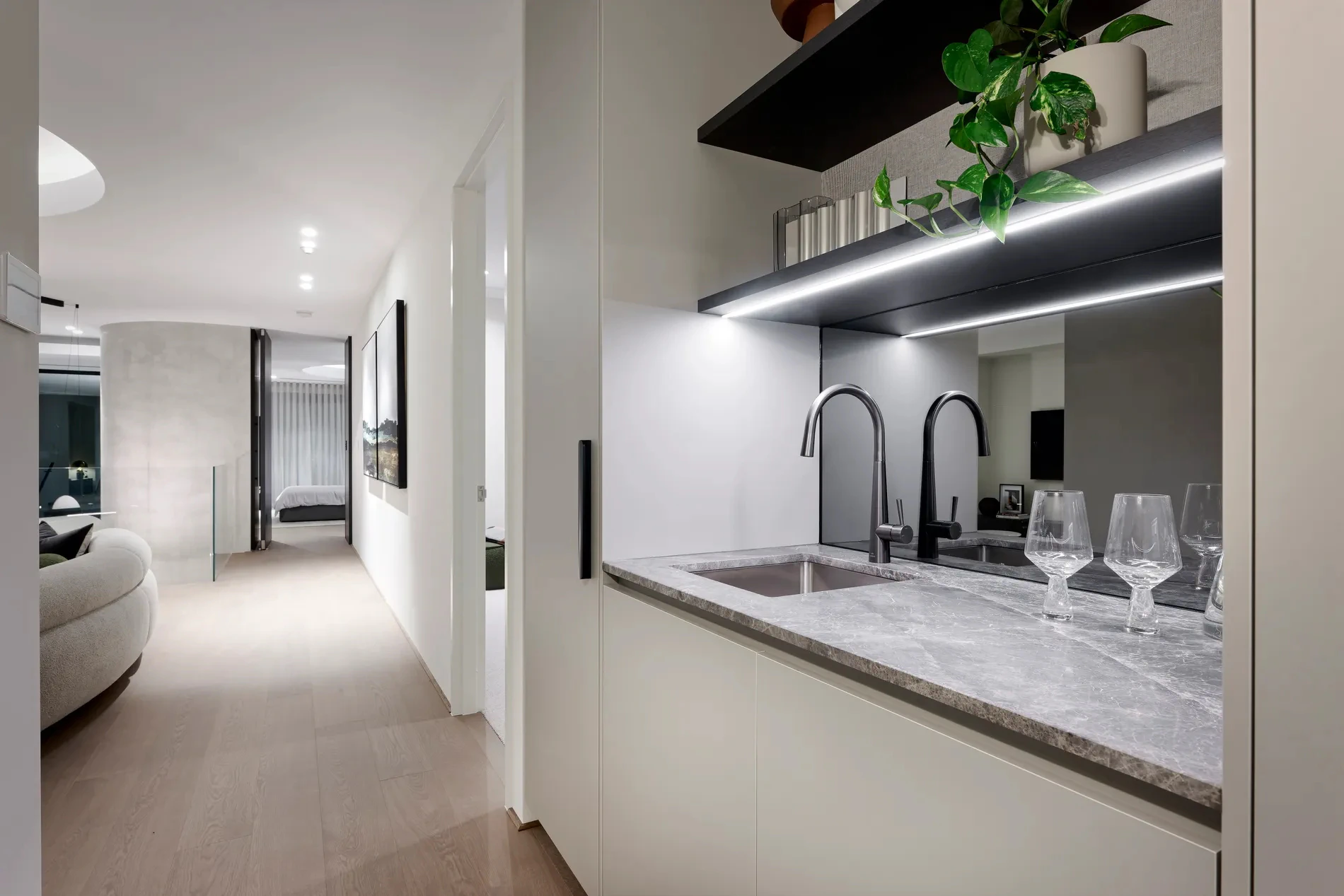 Kitchen countertop with three wine glasses on a grey marble surface