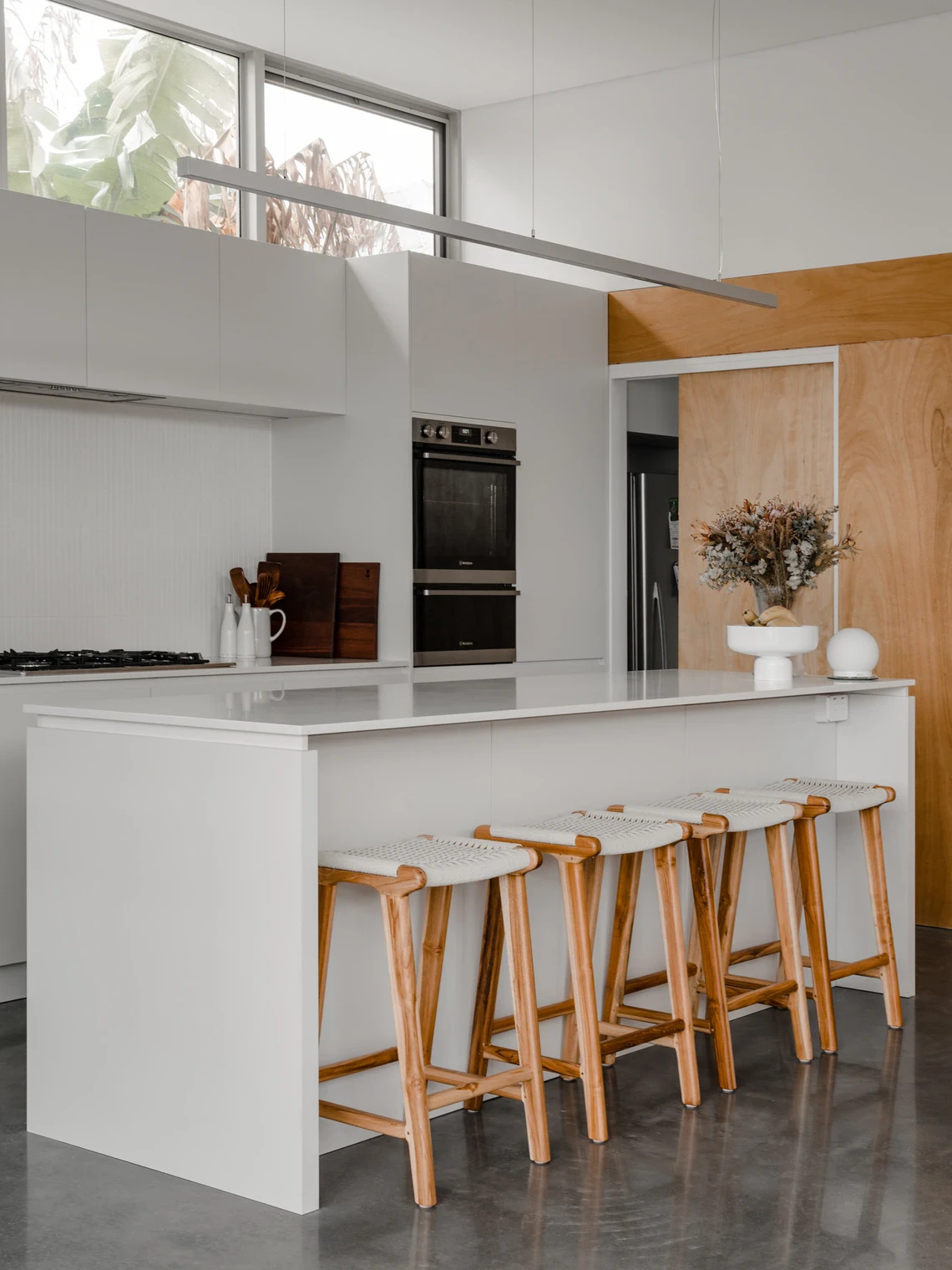 White kitchen island with wooden barstools