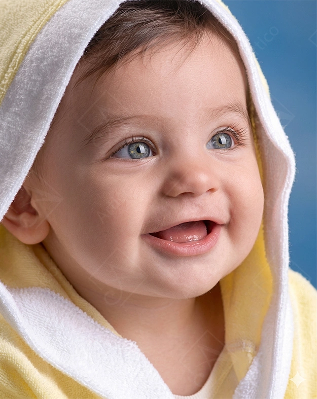 Articoo - Smiling baby girl with green eyes under a yellow blanket - Articoo-977882
