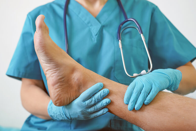 Doctor checking patient's foot and ankle for any signs of injury.