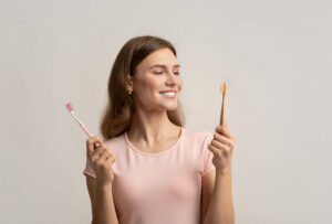 Woman holding toothbrushes deciding when she should change her toothbrush.