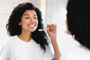 girl brushing teeth to prevent threats to her oral health