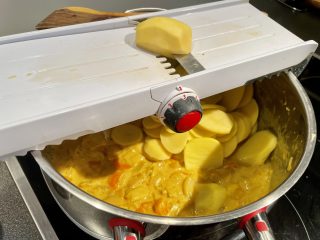 Kartoffeln direkt in die Kraut-Sauce hacheln - kurz aufkochen verkürzt die Zeit im Backrohr für den Auflauf