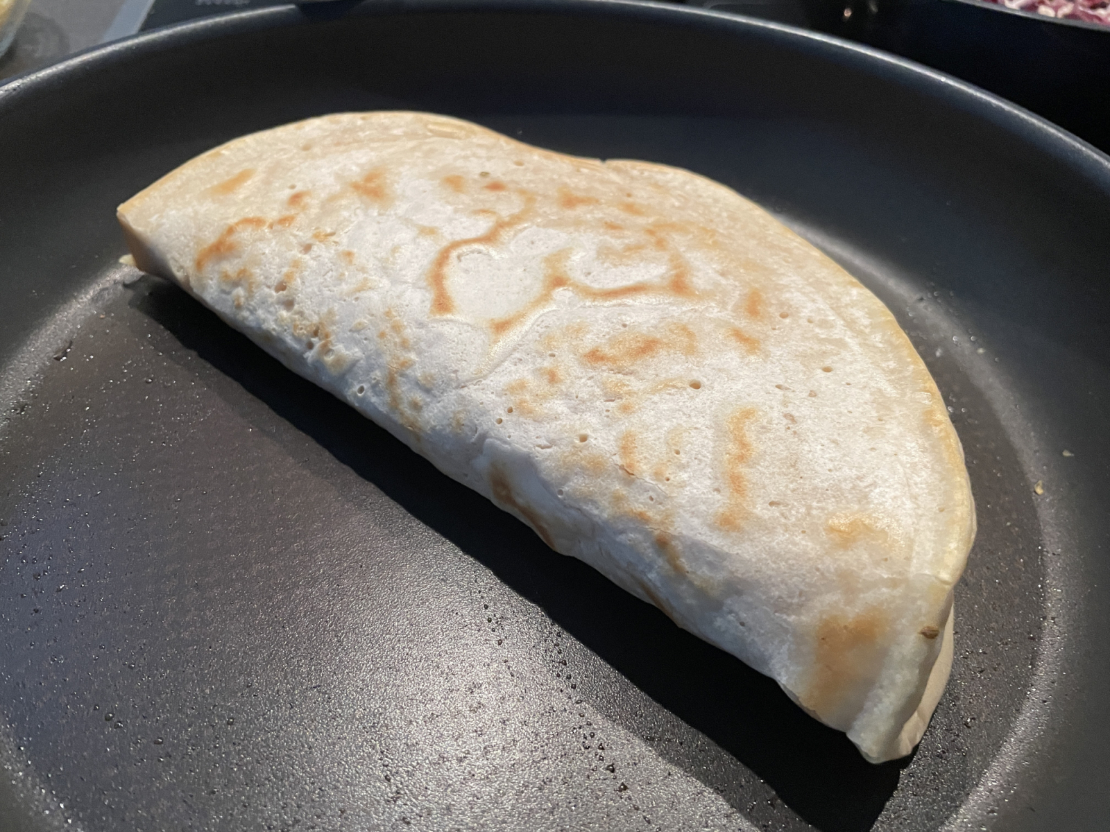 Das Zusammenklappen geht gut, wenn der Teig noch nicht zu kross ist. Daher erst das gefaltete Pfannenbrot stärker braten.