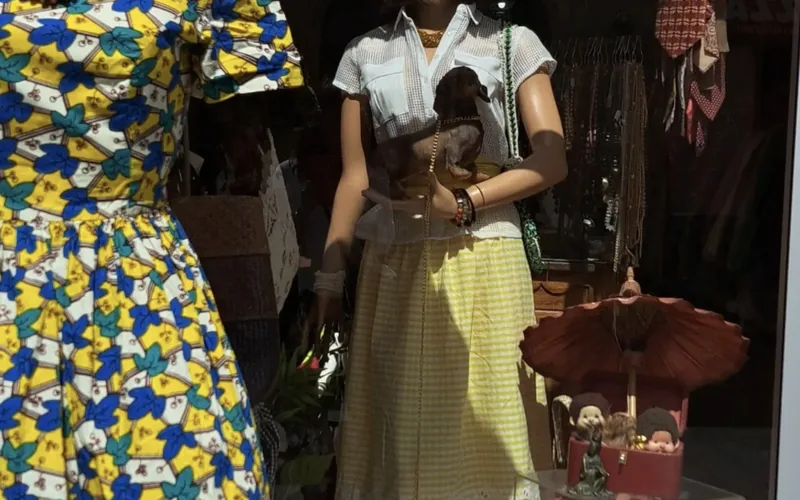 La vitrine de la friperie Déclic, rue des Augustins à Bordeaux : une robe en wax et une jupe vichy sur des mannequins