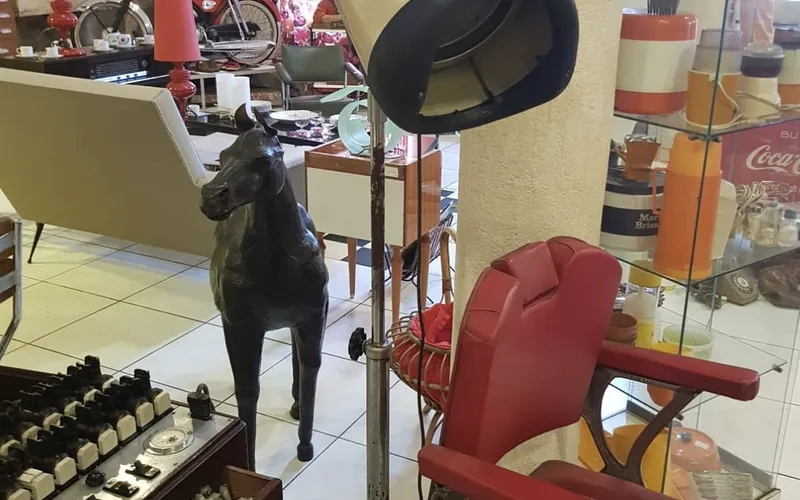 Fauteuil de barbier, casque de coiffeur et cheval en cuir parmi le mobilier des années 60 de L'Entrepôt Saint-Germain, à Bordeaux
