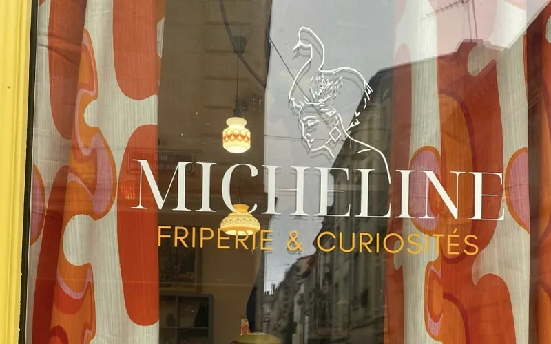 La vitrine de Micheline, friperie et curiosités de la rue Camille Sauvageau à Bordeaux, entre des rideaux orange des années 70