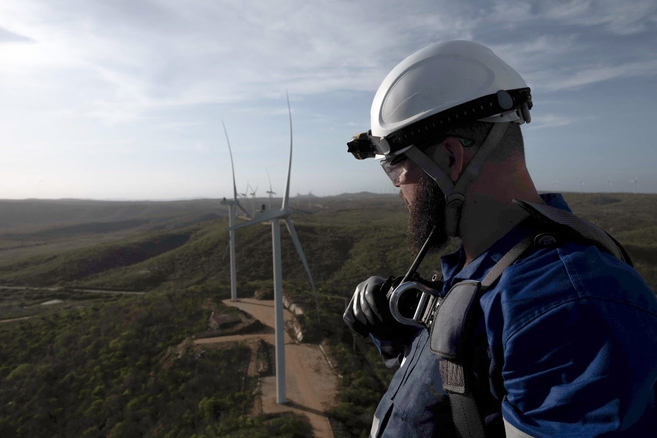 Colaborador da casa dos ventos olhando para os aerogeradores