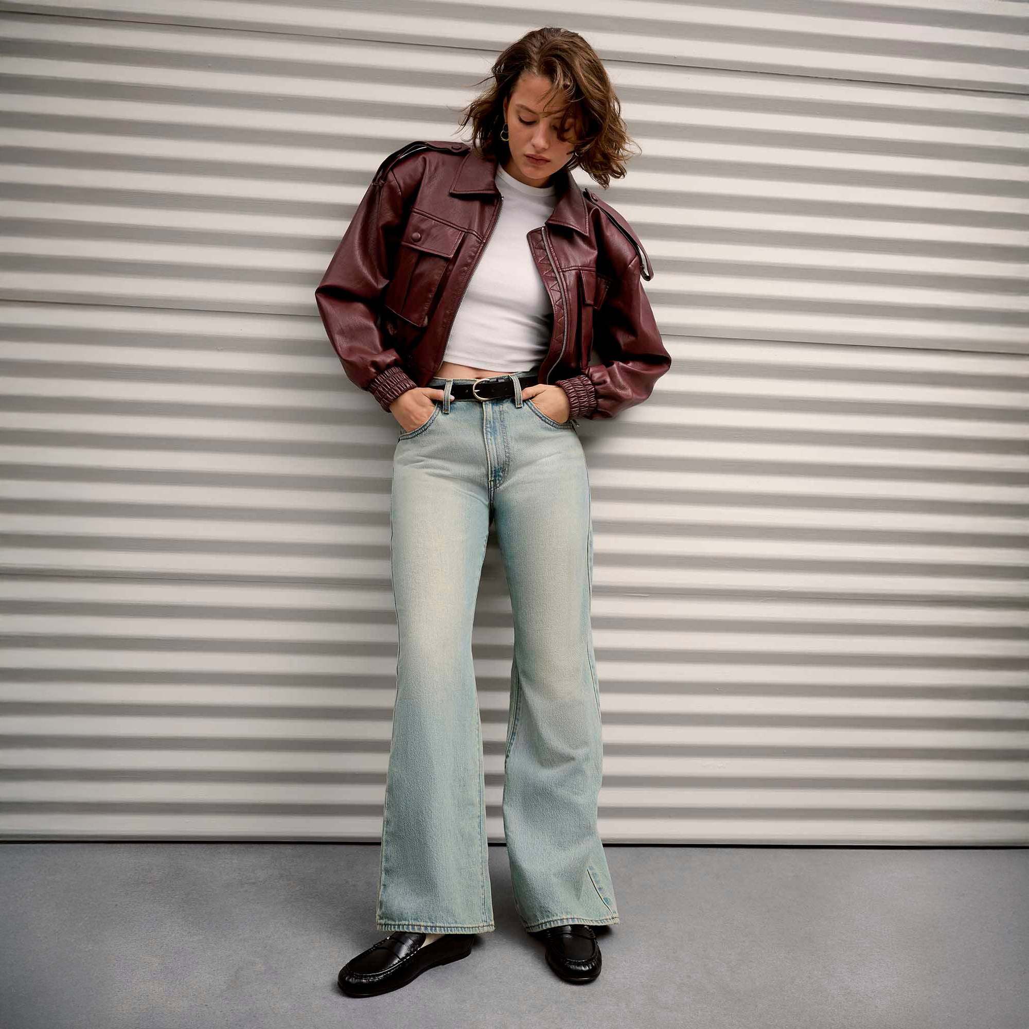 Woman wearing whit shirt, jeans, and leather jacket